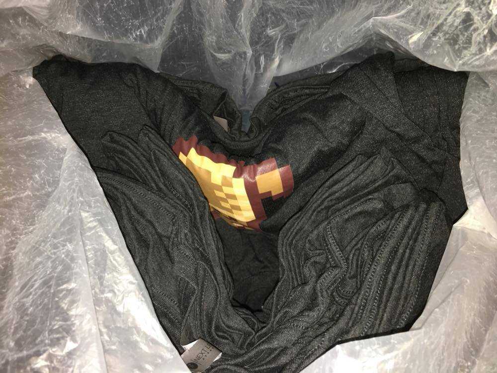 Plastic bag containing the Milo Dinosaur t-shirts
